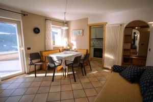 Sun & Mountains Cavalese في كافاليسي: مطبخ وغرفة طعام مع طاولة وكراسي