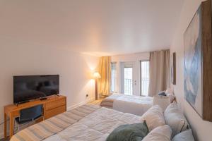 a hotel room with two beds and a flat screen tv at Big Sunshine in Mont-Tremblant