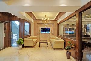 eine Lobby mit Sofas und einem TV in einem Gebäude in der Unterkunft Diamond Admire Hotel & Banquets by MMD in Noida