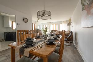 uma sala de jantar com uma mesa de madeira e cadeiras em Big Sunshine em Mont-Tremblant