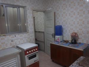 uma pequena cozinha com um fogão e um balcão em Alexandre Mayer em Peruíbe