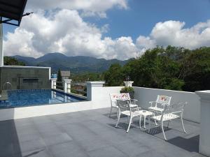 a patio with two chairs and a swimming pool at Pesona Halimun Cisarua in Paragajen