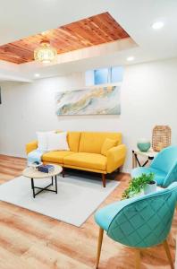 un soggiorno con divano giallo e sedie blu di Unique, Modern and Lovely Space! a East Providence