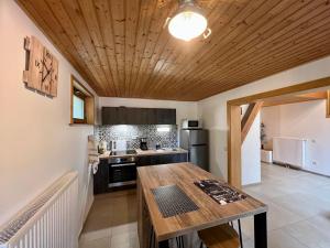 a kitchen with a wooden ceiling and a wooden table at Gîte Le Saulcy, 3 pièces, 4 personnes - FR-1-589-413 in Le Saulcy