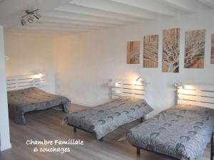 deux lits dans une chambre avec des tableaux au mur dans l'établissement Grande maison familiale avec jardin, terrasse et équipements de loisirs, proche forêt de la Charnie - FR-1-410-297, à Chemiré-en-Charnie