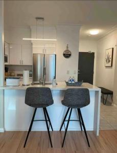 a kitchen with a white counter and two bar stools at 1BR Condo DWTN Toronto - free Parking, Gym & Pool in Toronto