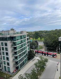 een trein die langs een gebouw naast een straat rijdt bij 1BR Condo DWTN Toronto - free Parking, Gym & Pool in Toronto