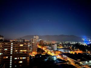 uma cidade iluminada à noite com edifícios em City House Andes Bello em Temuco