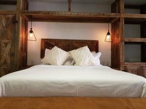 a bedroom with a large white bed with two lights at El Andador House Downtown with Free Parking And Aire AC in San Miguel de Allende