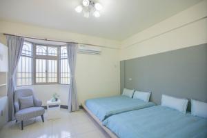 1 dormitorio con 1 cama, 1 silla y 1 ventana en 卡薩行旅一館 包棟民宿, en Jinhu