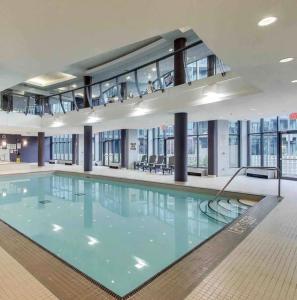 een groot zwembad met blauw water in een gebouw bij 1BR Condo DWTN Toronto - free Parking, Gym & Pool in Toronto