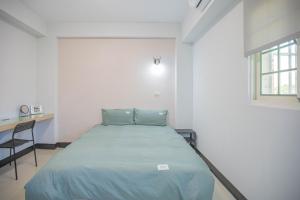 1 dormitorio con cama, escritorio y ventana en 卡薩行旅二館 包棟民宿, en Hsia-hsing
