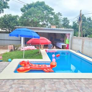 una piscina con un perro inflable y una sombrilla en Harapy y Naipy en Puerto Iguazú