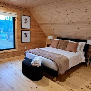 ein Schlafzimmer mit einem großen Bett in einem Blockhaus in der Unterkunft Islander Lodge - Lochaber Lake Lodges in Antigonish
