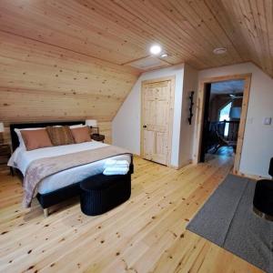 ein Schlafzimmer mit einem Bett und einer Holzdecke in der Unterkunft Islander Lodge - Lochaber Lake Lodges in Antigonish