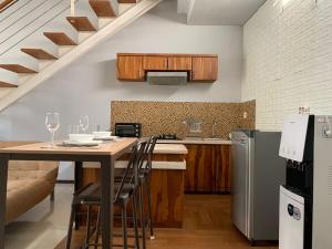 uma cozinha com uma mesa com cadeiras e um frigorífico em Balcony Living Apartment em Seminyak