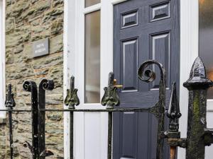 a black gate in front of a house with a door at Bryn Marian in Blaenau-Ffestiniog