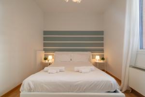 a bedroom with a white bed with two towels at 4 Star Family & Friends Apt - Self Check-in in Bologna