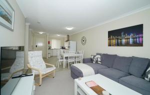 ein Wohnzimmer mit einem blauen Sofa und einem Tisch in der Unterkunft 6 Light Bright Home In South Perth in Perth