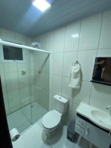 uma casa de banho com um chuveiro, um WC e um lavatório. em Pousada Route 58 em Gravataí