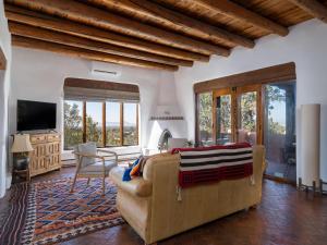 ein Wohnzimmer mit einem Sofa und einem TV in der Unterkunft Casa De Oro in Santa Fe