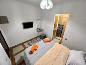 een slaapkamer met een bed met oranje handdoeken erop bij NEAR THE PYRAMIDS Inn in Caïro