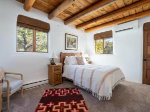Schlafzimmer mit einem Bett, einem Stuhl und Fenstern in der Unterkunft Casa De Oro in Santa Fe
