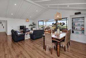 a living room with a dining room table and chairs at Seaglass - Karikari Peninsula Holiday Home in Kaitaia