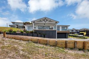 a house with a fence in front of it at Seaglass - Karikari Peninsula Holiday Home in Kaitaia