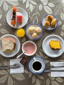 a table topped with plates of different types of food at Acomodare Hotel in Tubarão