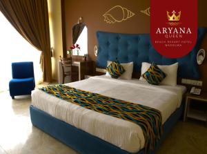 1 Schlafzimmer mit einem Kingsize-Bett und einem blauen Kopfteil in der Unterkunft Aryana Queen Beach Resort in Wadduwa