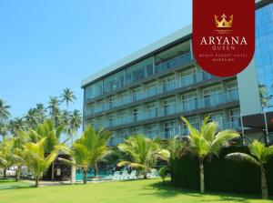 ein Hotel mit Palmen vor einem Gebäude in der Unterkunft Aryana Queen Beach Resort in Wadduwa