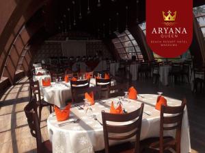a group of tables with orange napkins on them at Aryana Queen Beach Resort in Wadduwa