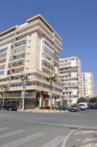 a large building with cars parked in a parking lot at Appartement 5 etoiles agadir vue mer in Agadir