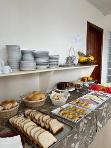 um buffet com pão e pastelaria sobre a mesa em Acomodare Hotel em Tubarão