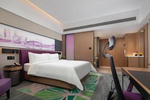 una camera d'albergo con letto, scrivania di Hampton by Hilton Shenzhen Baoan Stadium a Shenzhen