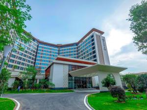 a hotel with a large building in front of it at Guangzhou Qiling LN DF Hotel in Huadu
