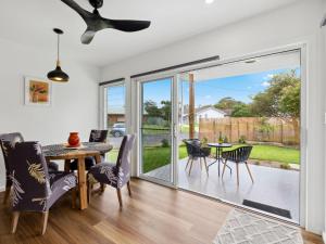 a dining room with a sliding glass door leading to a patio at Little Kim Close in Woolgoolga