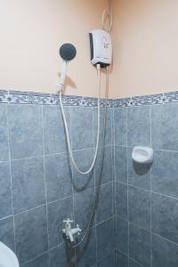 a shower with a blow dryer on the wall of a bathroom at Seashore Garden Resort in Moalboal