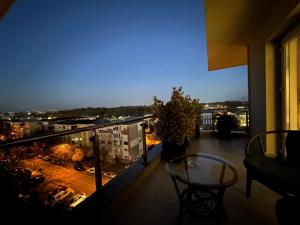 a balcony with a table and a view of a city at Luxury apartment , Private parking, Self Check-in64 in Craiova