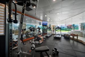 a gym with treadmills and machines in a room at Mardhiyyah Hotel and Suites in Shah Alam