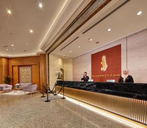 two men standing at a podium in a lobby at Mardhiyyah Hotel and Suites in Shah Alam