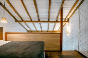 a bedroom with a bed and a wooden ceiling at Pousada Hanalie in Praia do Rosa