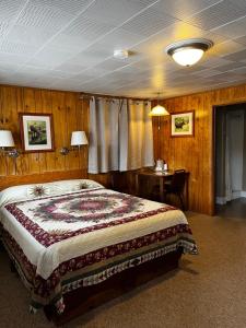 a bedroom with a large bed and a desk at Lazy Duck Inn in West Yellowstone