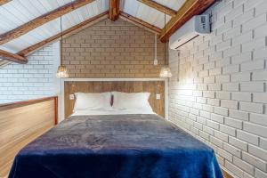 a bedroom with a bed in a brick wall at Pousada Hanalie in Praia do Rosa