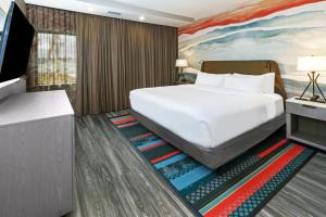 1 dormitorio con 1 cama blanca grande y TV en Hotel Indigo Spring - Woodlands Area, an IHG Hotel, en Spring