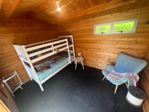 una camera con letto a castello e una sedia in una cabina di Mill Bay Charmer a Mangonui