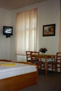 a bedroom with a bed and a table and chairs at Pension Wedding in Berlin