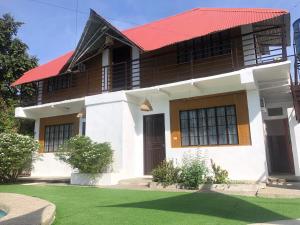 une maison blanche avec un toit rouge dans l'établissement Balai Roco, à Bauang