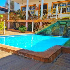 a swimming pool at a resort with a house at Hotel Montanhas de Minas in Diamantina